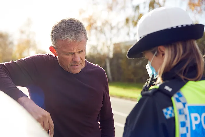 Image of man with female police officer representing Types of Drug Offenses