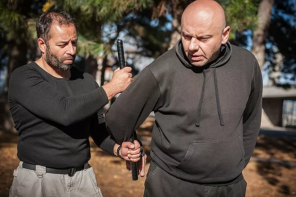 Man being subdued with police baton representing Assault Charges