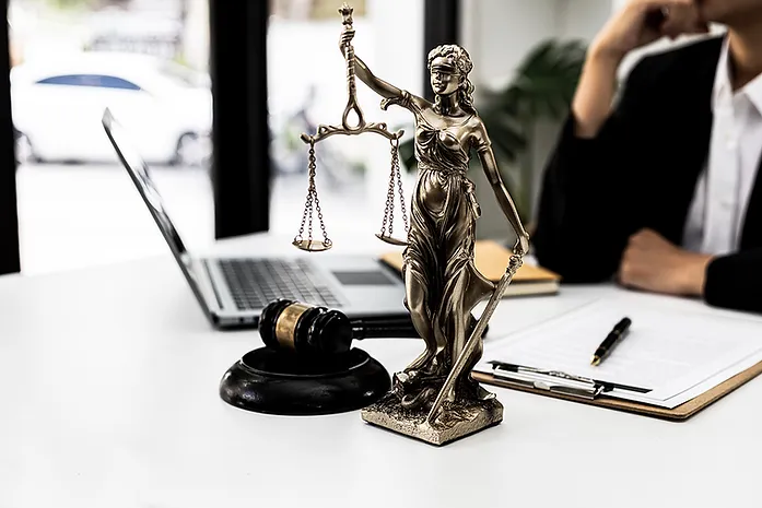 Desk with Lady Justice, Gavel, laptop and clipboard on desk representing Facing a Mesdemeanor