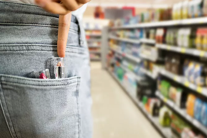 Women pushing stolen lipstick into her pocket representing theft crimes in Tennessee